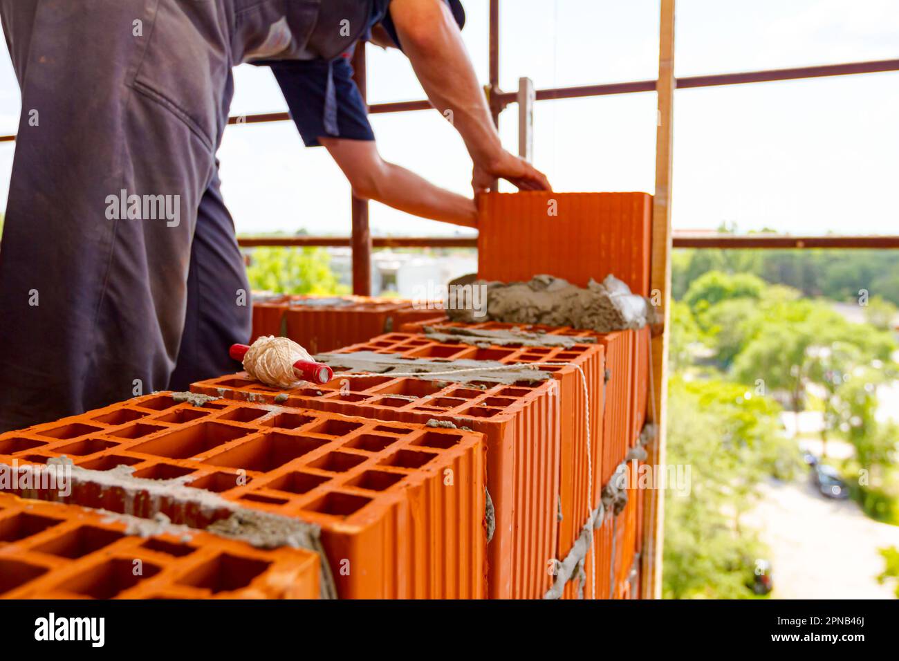 Spool of construction string line placed in red blocks. Tool to help worker  for set straight distances on new edifice, in background mason uses red bl  Stock Photo - Alamy