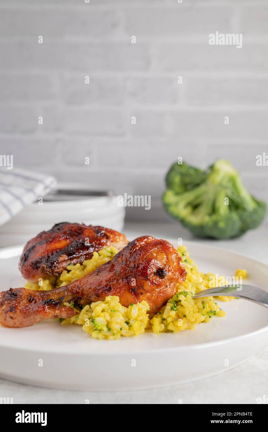 Oven baked and glazed chicken drumsticks with curry, broccoli brown