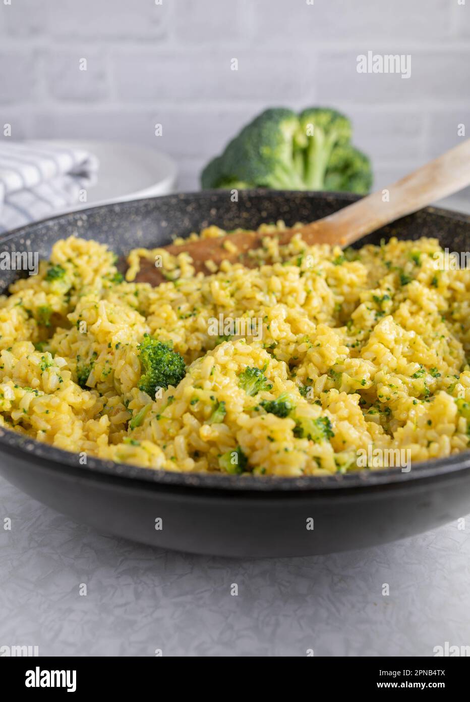 Curried brown rice with broccoli in a skillet Stock Photo