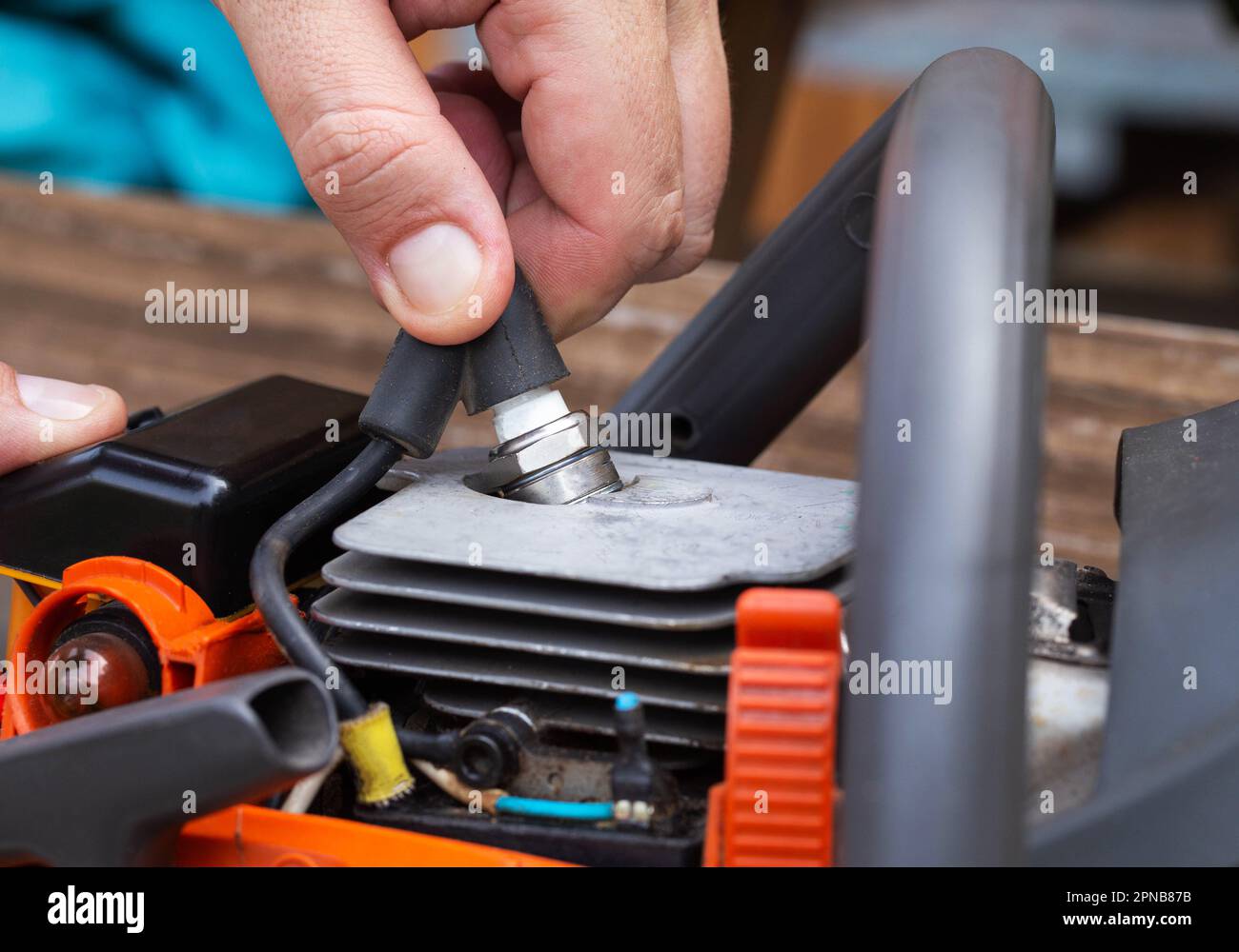 Removing the spark plug from the chainsaw cylinder. Replacing a new
