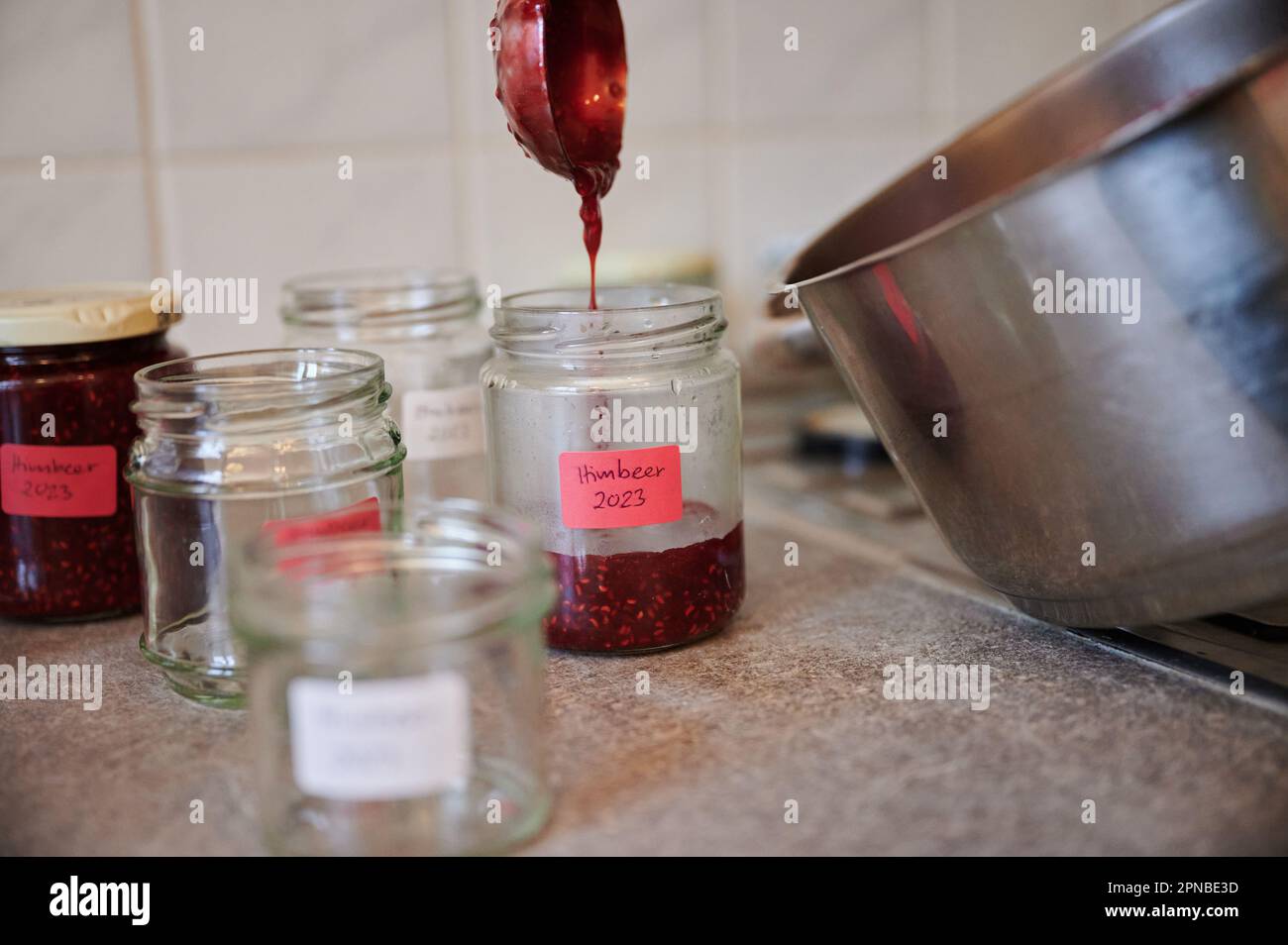 Berlin, Germany. 17th Apr, 2023. A woman fills raspberry jam from a pot ...