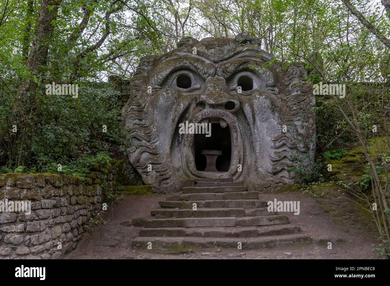 The ancient statue representing the ogre, in the park of monsters in Bomarzo, Italy (Translation: Every thought flies) Stock Photo