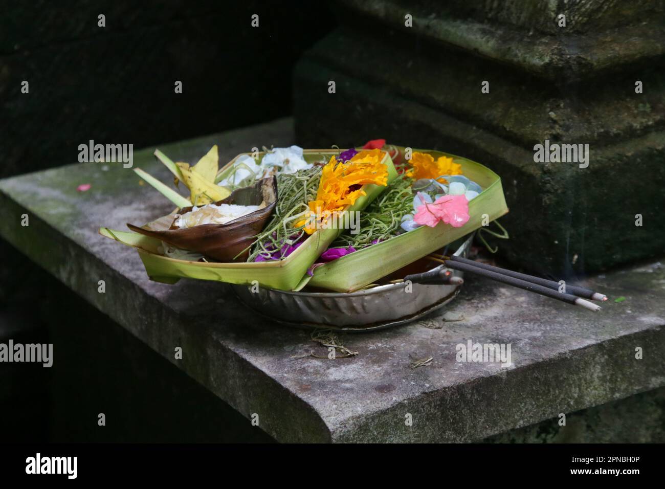 Canang sari, woven bamboo container with rice, flowers, incense, sweets and fruits. This is an offering to the Gods, as a gesture of gratitude in Bali Stock Photo