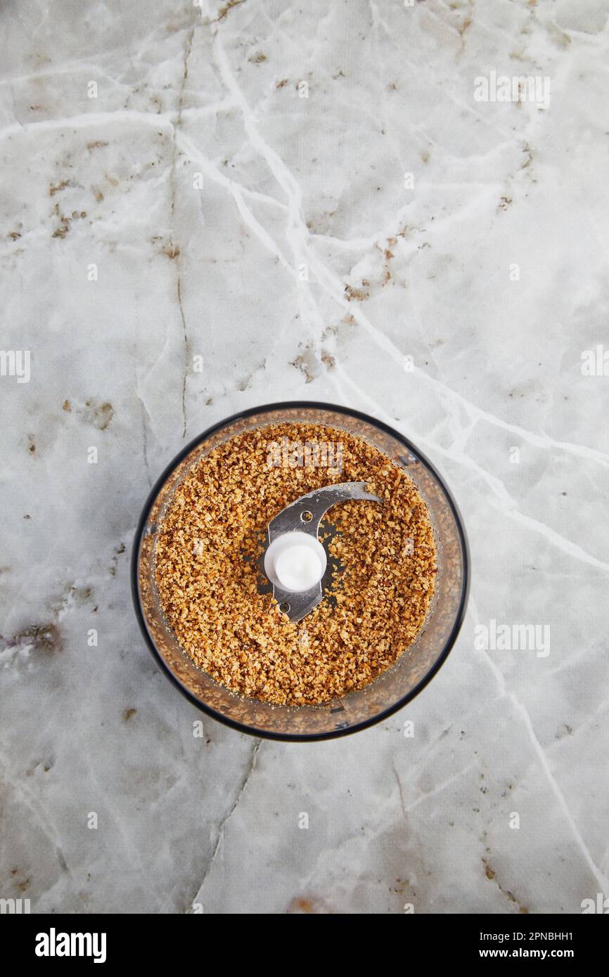 Top view of blender with crushed biscuits placed on marble counter