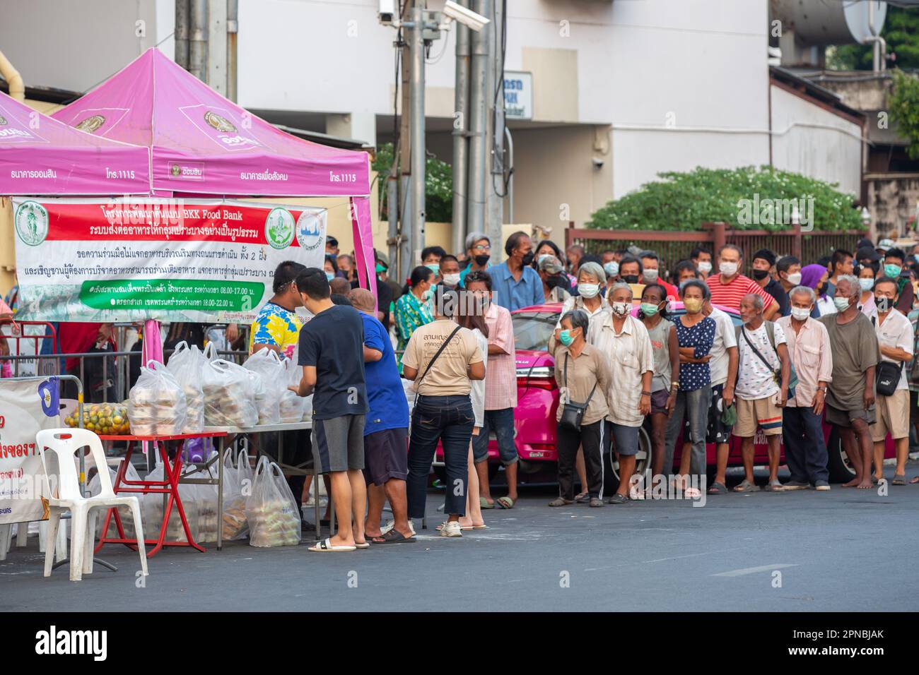 Bangkok, Thailand - April 15, 2023: People waiting in line to receive food from Bangkok Food Bank initiative. Stock Photo