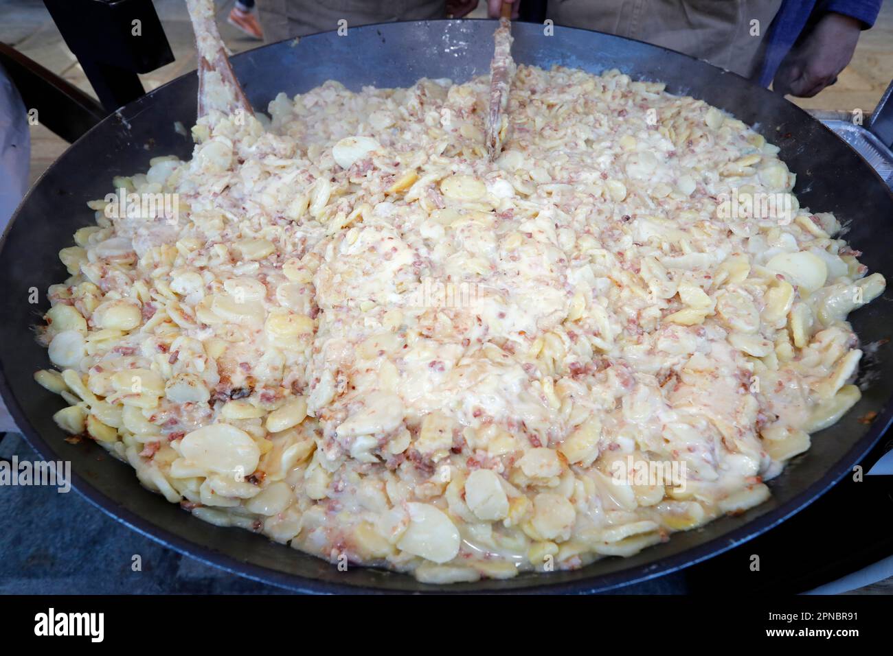 Giant fresh tartiflette, Savoy cheese, potatoes and ham  speciality in the French Alpes. Saint-Gervais. France. Stock Photo