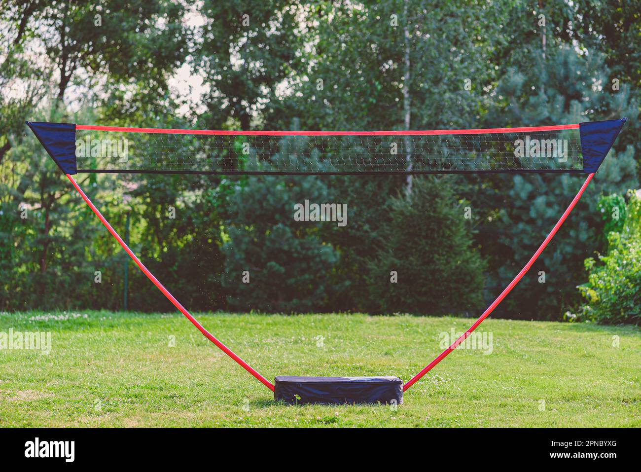 Portable badminton net and playing set at backyard lawn on summer day