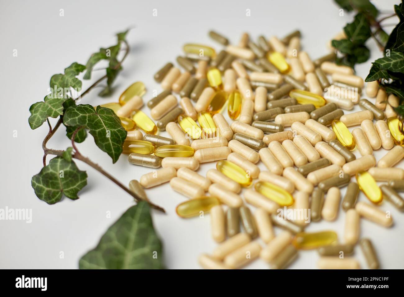 Pills, medical tablets with green plants, leaves on white background, Natural herbal medicine