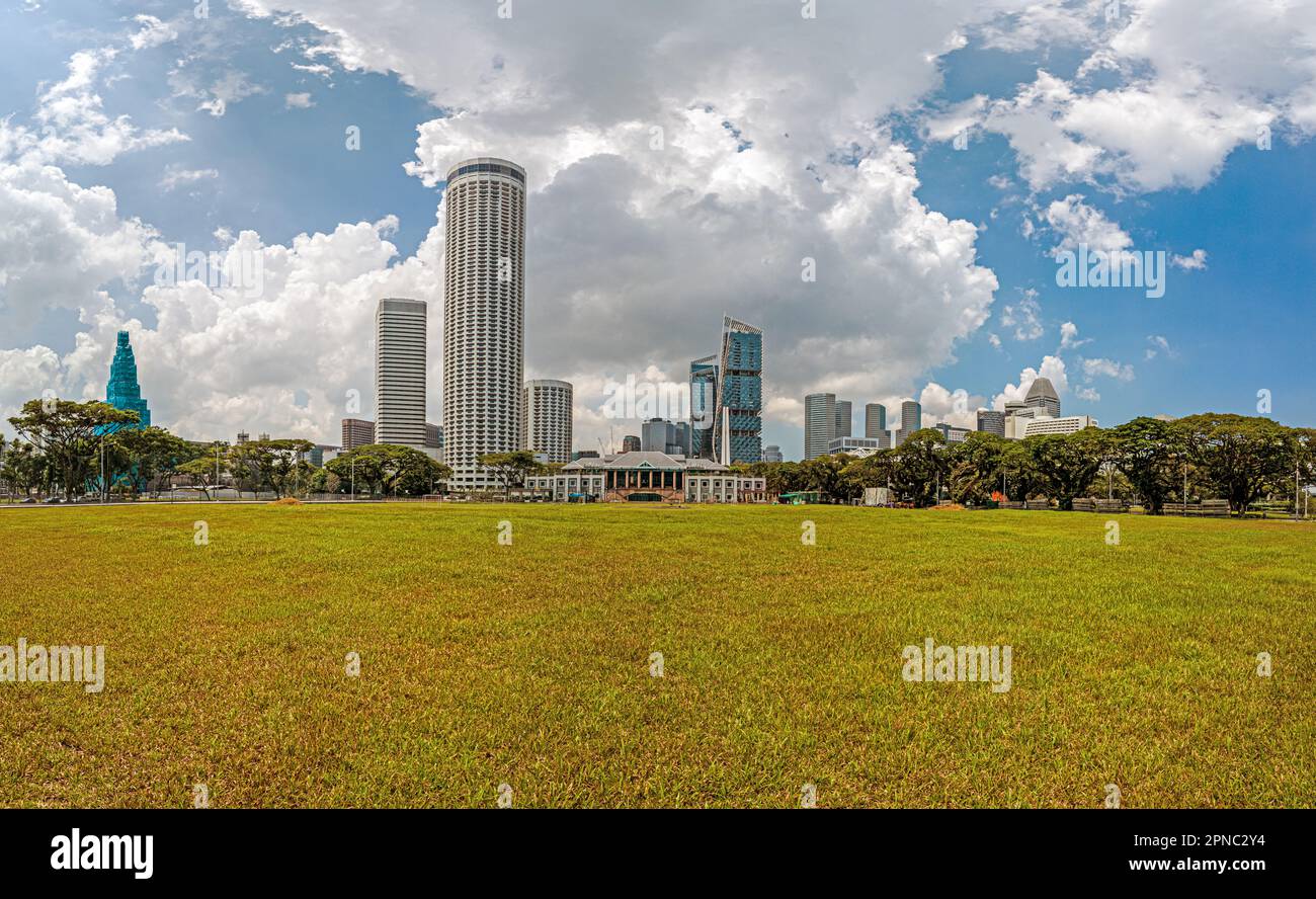 Picture over the historic Padang sports facility in Singapore with the skyline in the background during the daytime Stock Photo