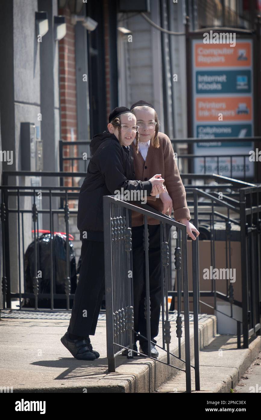 Hassidic buddies hang out on a stoop in Williamsburg, Brooklyn, New York City Stock Photo