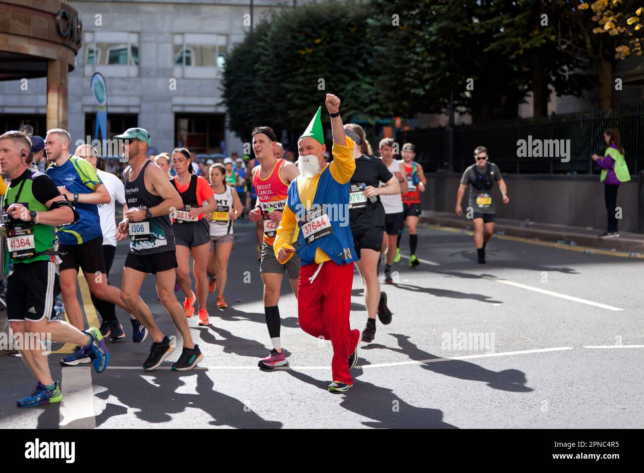 Ian Young (GBR), dressed as a Gnome, passing through Cabot Square on his way to finish 1380th, in the 45-49 Category of the 2022 London Marathon Stock Photo
