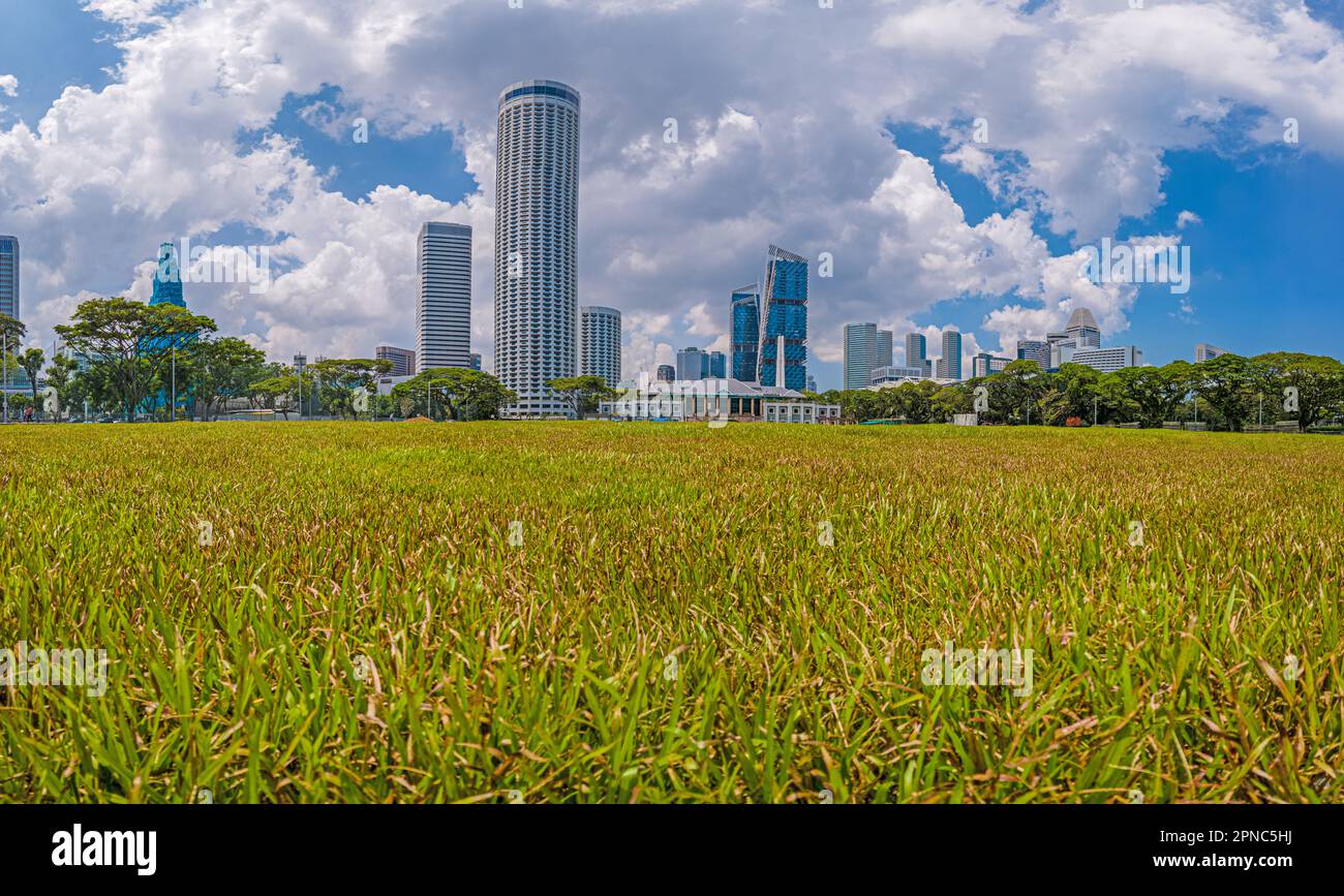 Picture over the historic Padang sports facility in Singapore with the skyline in the background during the daytime Stock Photo