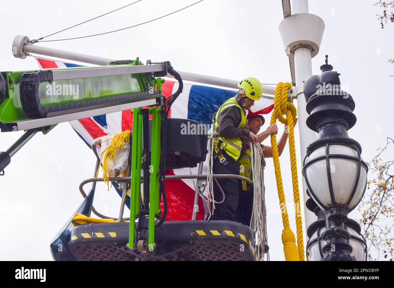 London, UK. 18th April 2023. Workers install Union Jacks in The Mall as