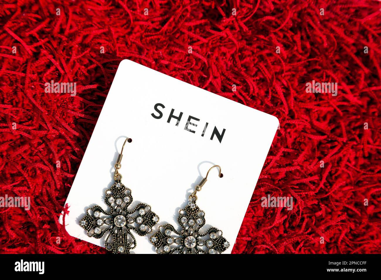 Ho Chi Minh City, Vietnam - April 18, 2023: Chinese online fast fashion retailer Shein logo on a jewelry product. Brand name on vintage style earrings Stock Photo