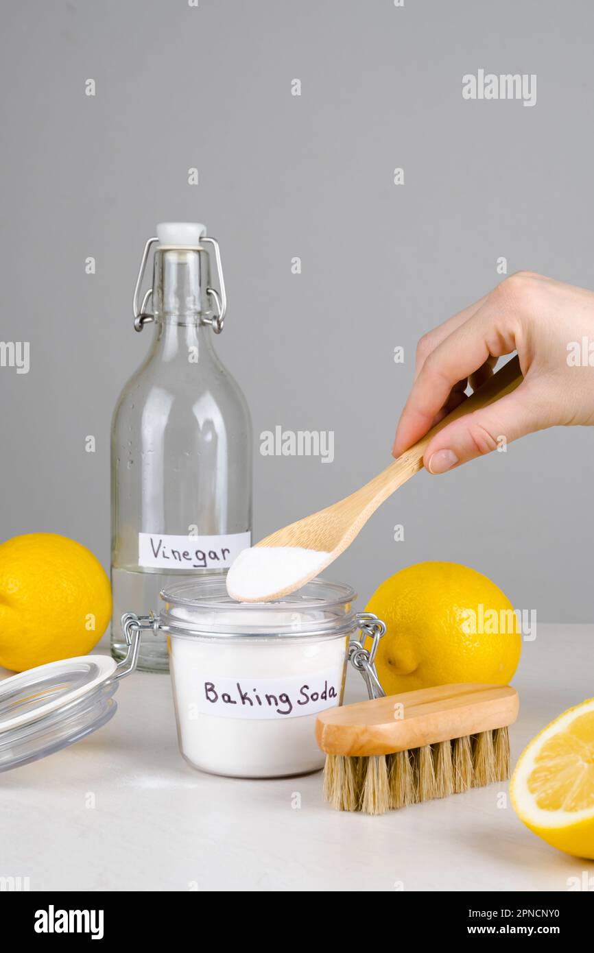 Baking soda, vinegar and lemon on a gray background.The concept ecological cleaning, disinfecting, removing stains Stock Photo