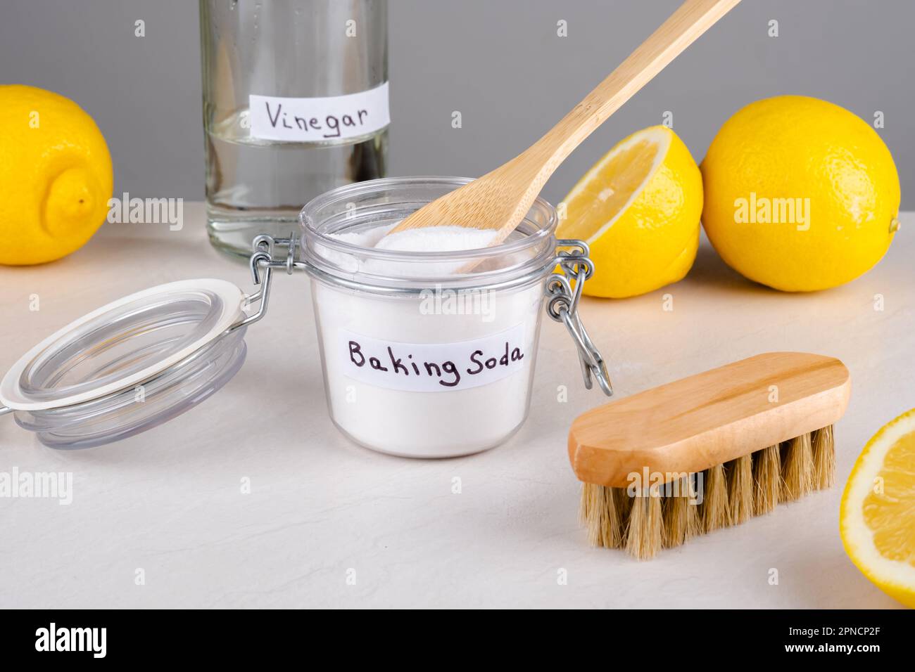 Baking soda, vinegar and lemon on a gray background.The concept ecological cleaning, disinfecting, removing stains Stock Photo