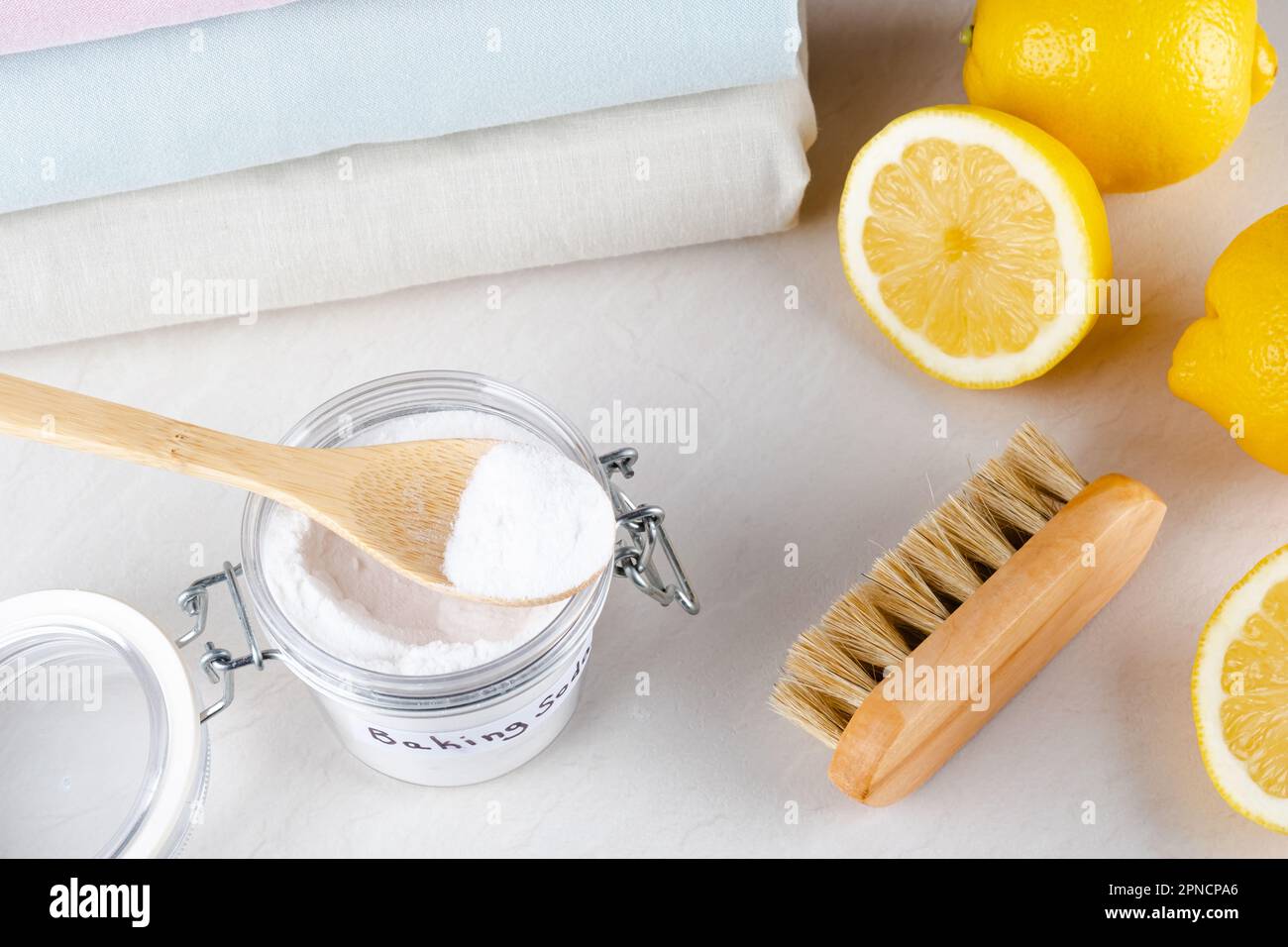 Eco friendly natural cleaners baking soda, lemon and clothing on a white table. isolated. top view. Stock Photo
