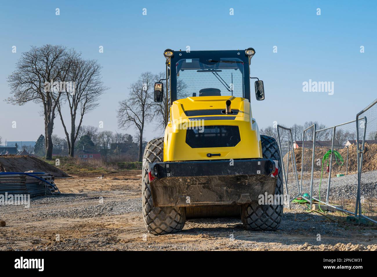 Wheeled tractor of yellow color at the construction site under the blue