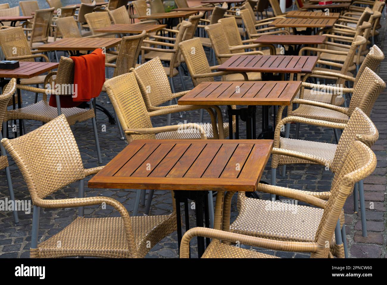 Free wooden tables and wicker chairs standing in rows near the summer ...