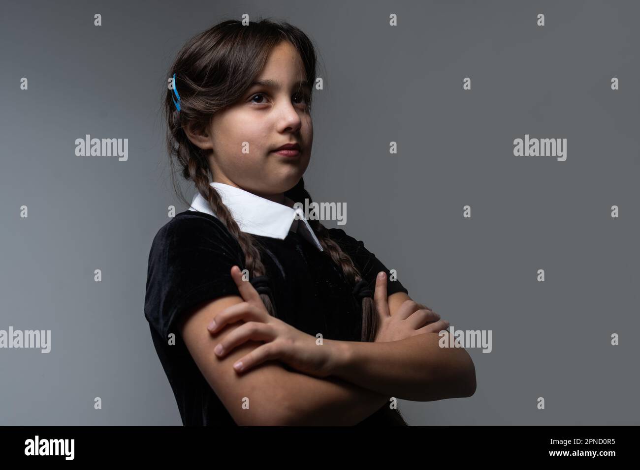 Portrait of little girl with Wednesday Addams costume during Halloween.  Serious expression and dark atmosphere with dark background Stock Photo -  Alamy