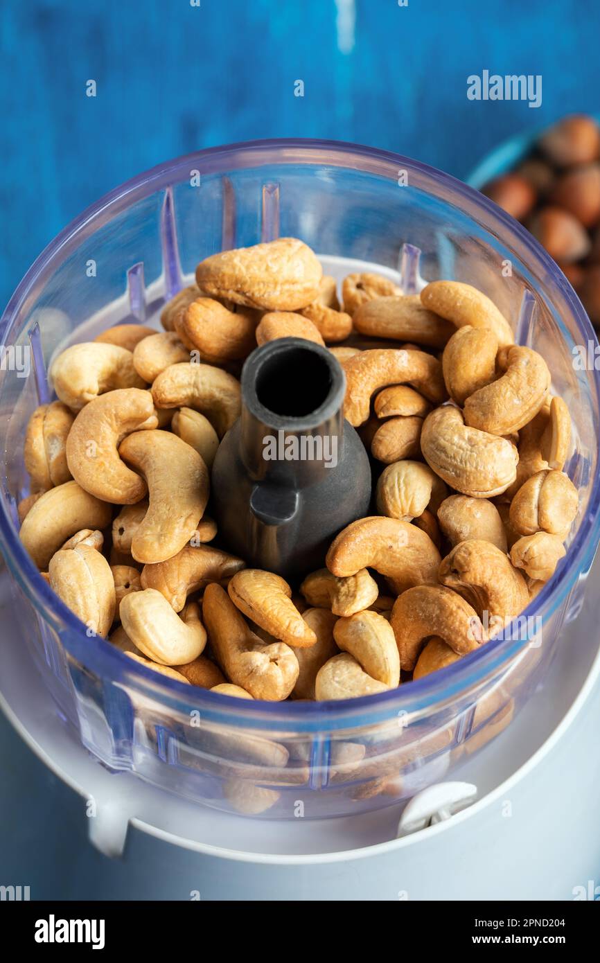 Cashews in the food in the food processor. Cashews in blender on a