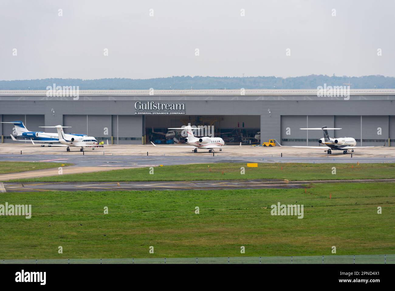 Gulfstream MRO hangar, Farnborough Airport, Hampshire, UK. Private jets parked outside. Maintenance, repair and operations hangar by VolkerFitzpatrick Stock Photo