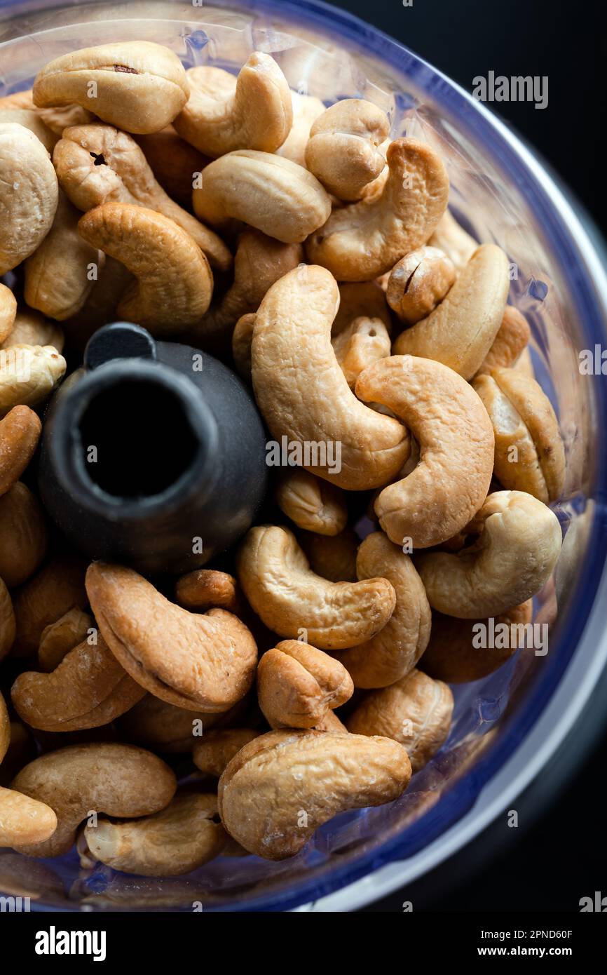 Cashews in the food in the food processor. Cashews in blender on a