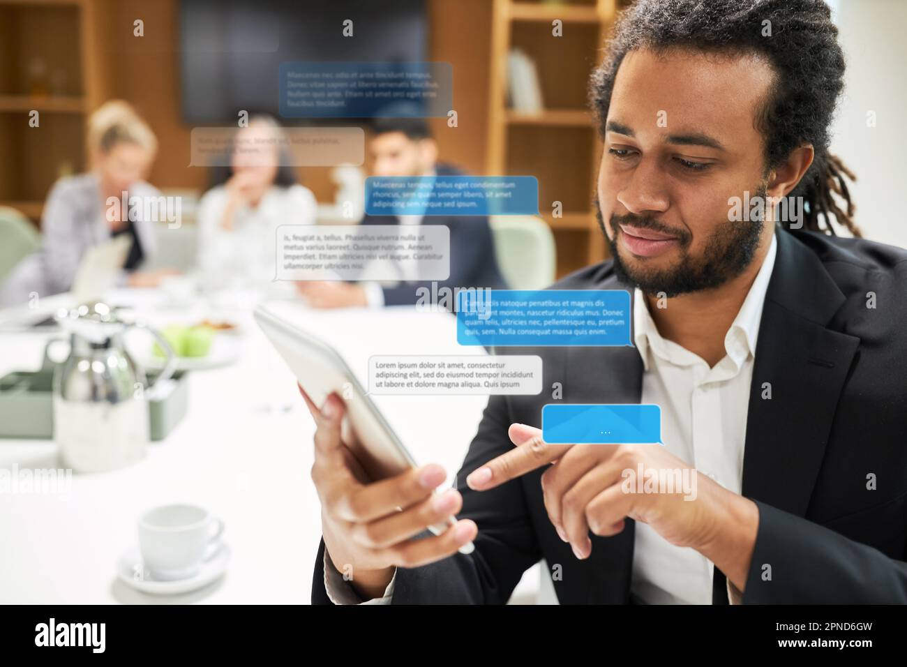 Business man typing sms or messenger message with popped up speech bubbles in conference room Stock Photo