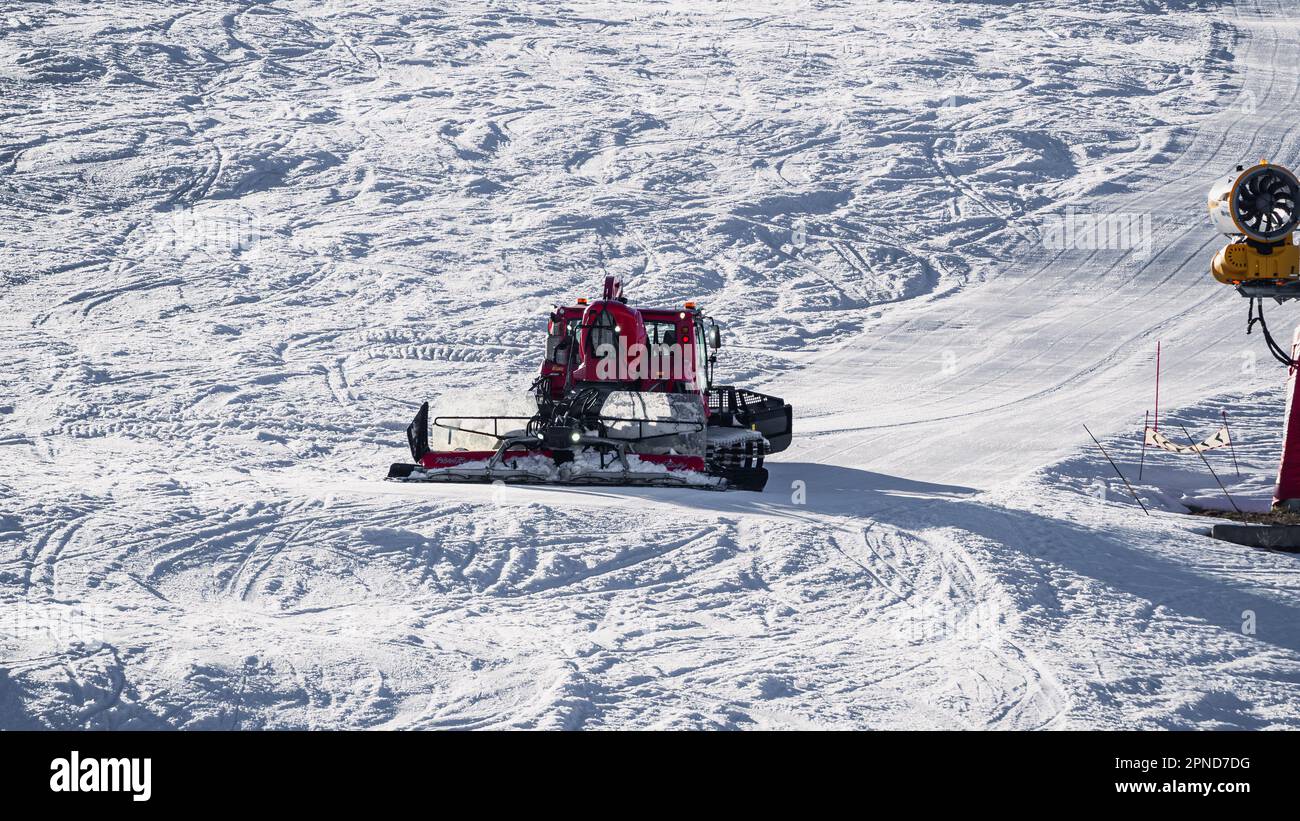 Huez, France - 9 April 2023: Snowcat, ratrack PistenBully - machine for snow preparation while working in Alpe D'huez Stock Photo