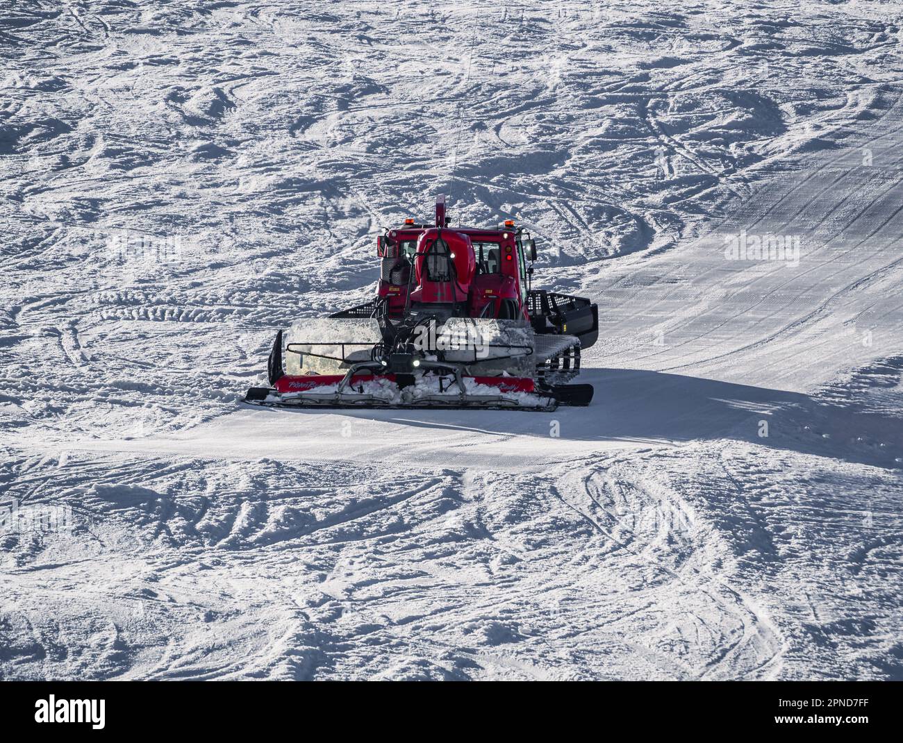 Huez, France - 9 April 2023: Snowcat, ratrack PistenBully - machine for snow preparation while working in Alpe D'huez Stock Photo