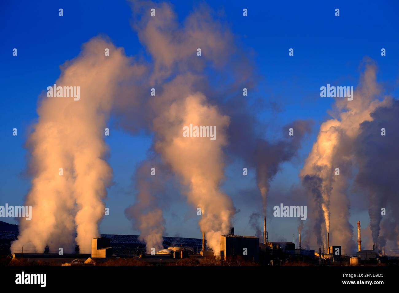 Factory chimneys spewing pollution into the sky smoke rising pollutants