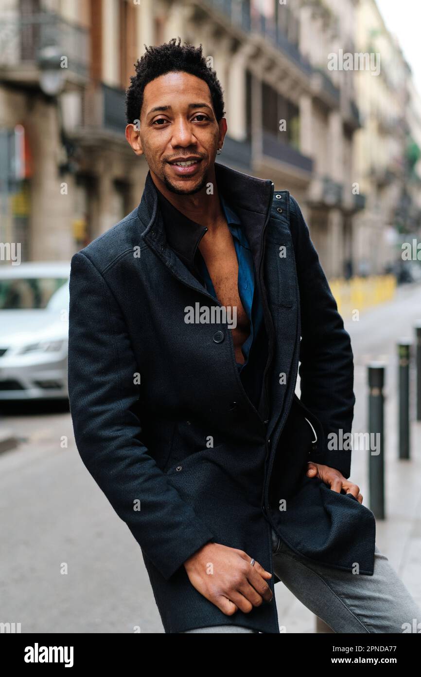 Confident stylish man looking at camera while posing outdoors in the street. Stock Photo