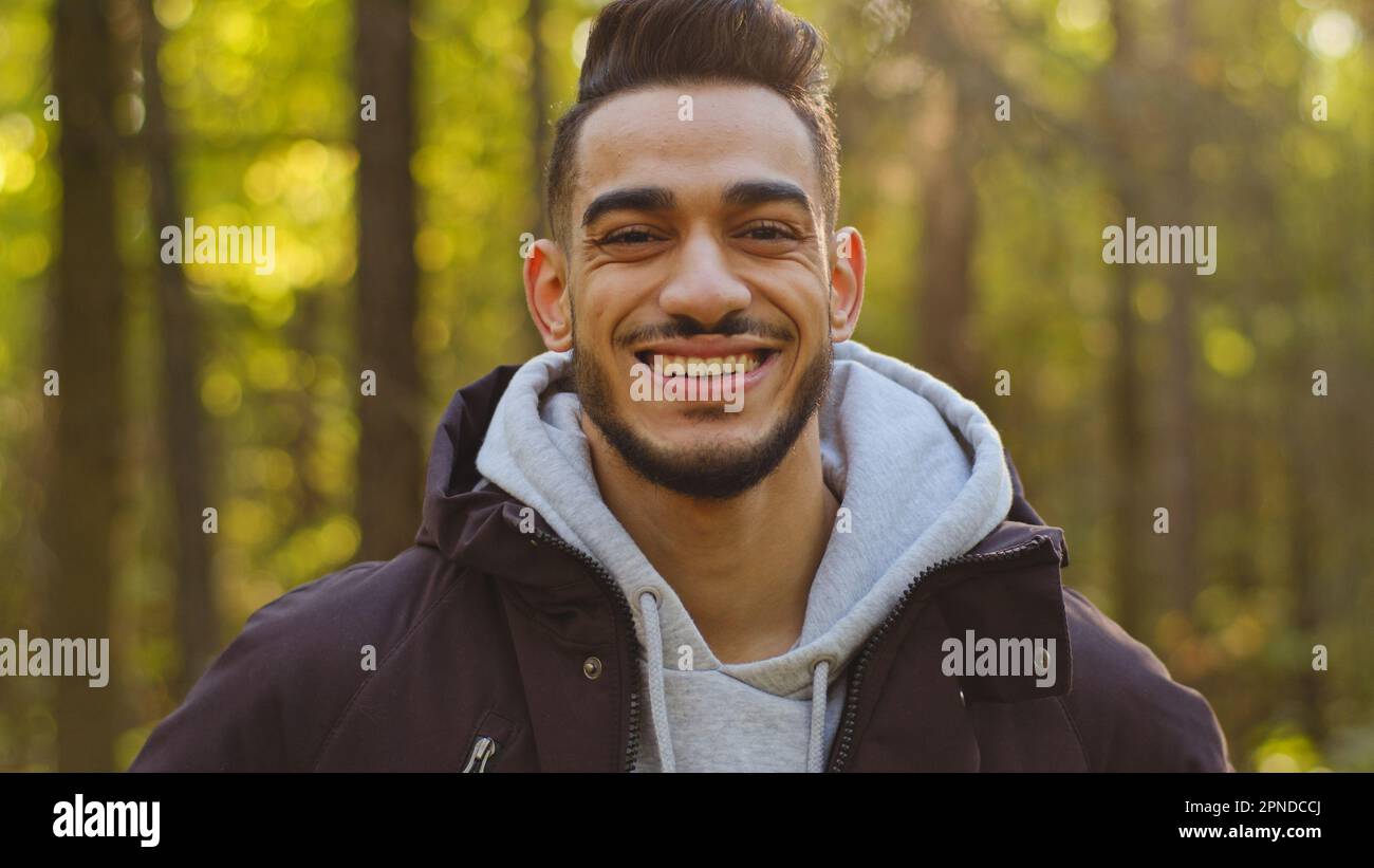 Male happy face portrait of young muslim smiling hispanic arabian guy posing outdoors looking at camera confident man forestry tourist engineer stands Stock Photo