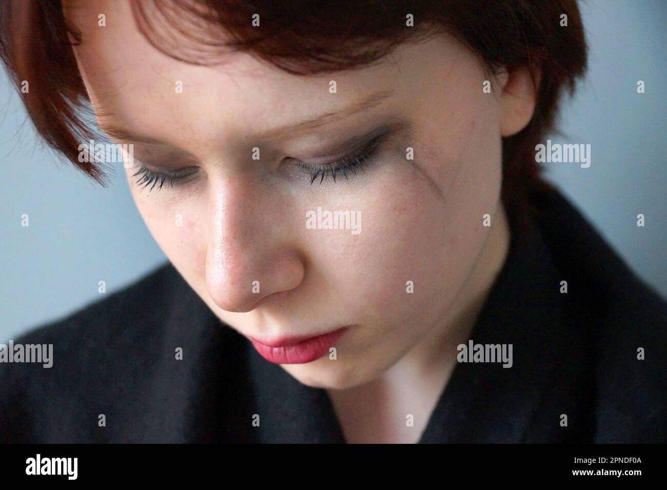 portrait of a sad teenager girl with closed eyes with mascara smeared from tears. Stock Photo