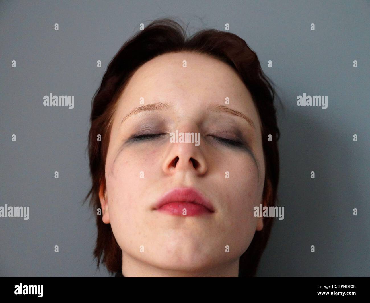 portrait of a sad teenager girl with closed eyes with mascara smeared