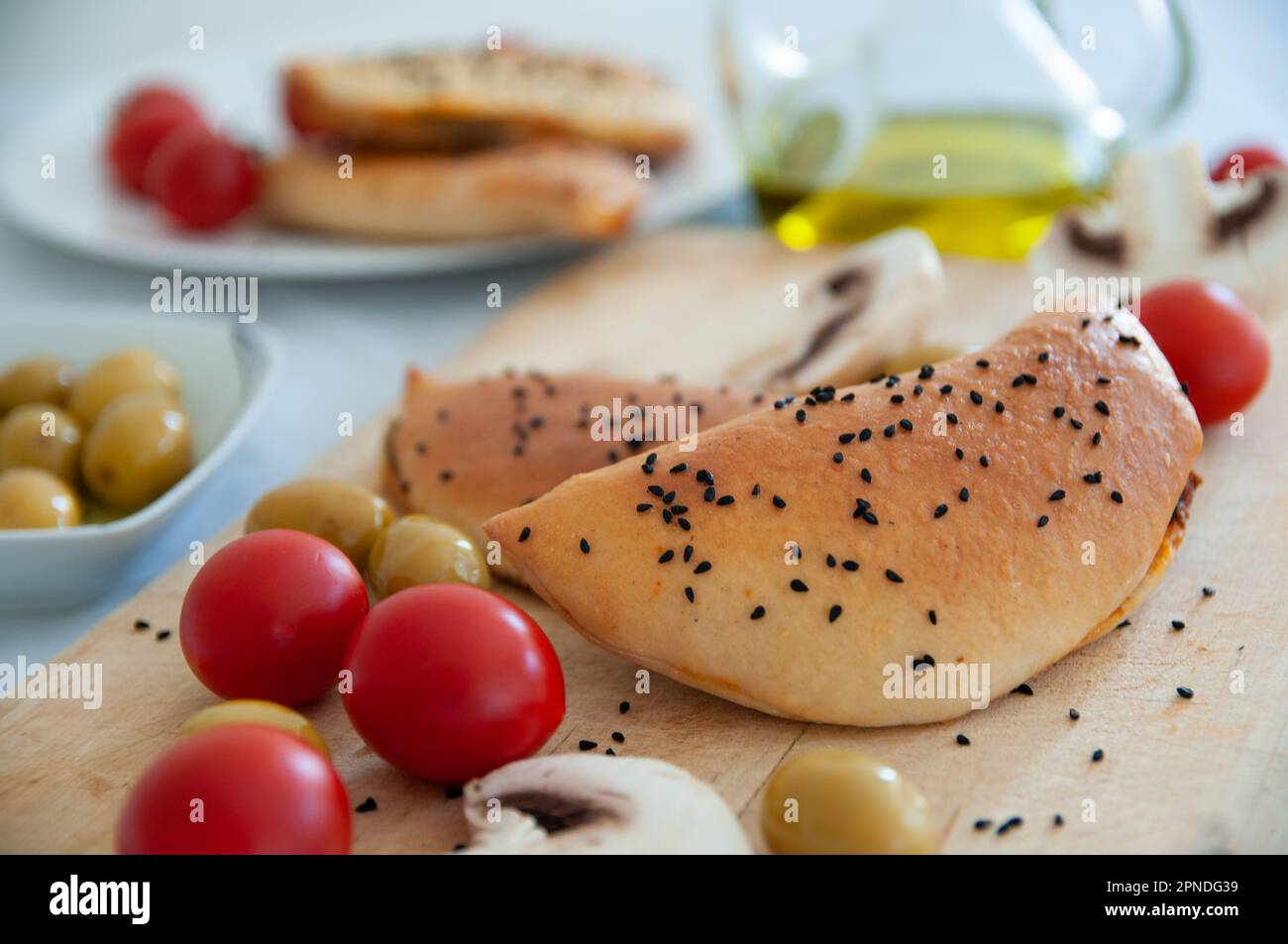 Cheese mushroom pie served with marinated olives and cherry tomatoes Stock Photo