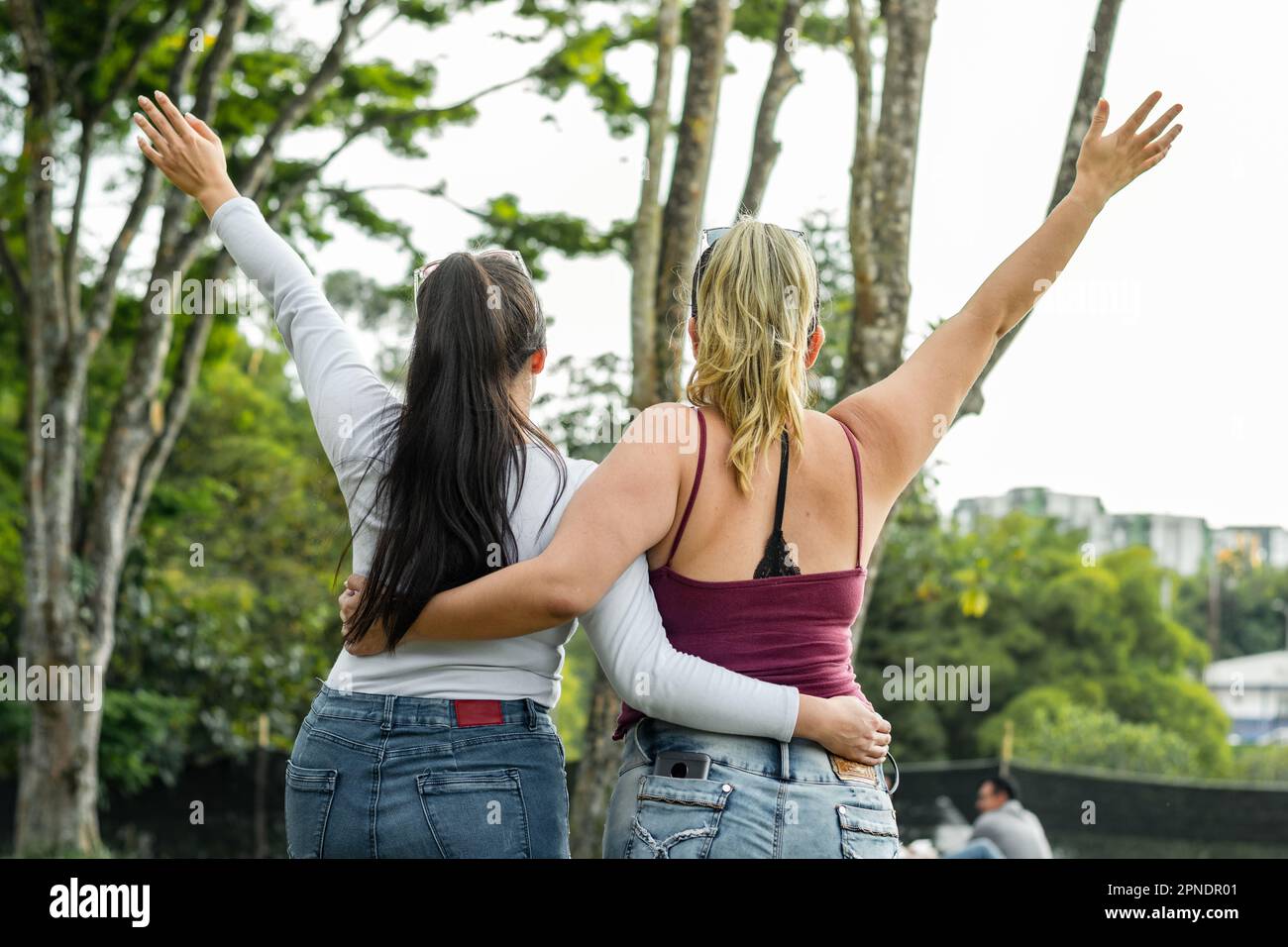 latina friends enjoying a sunny day in the park while taking a walk in the park Stock Photo