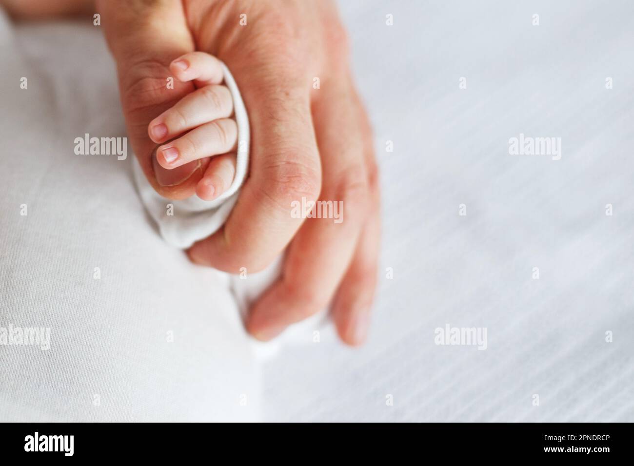 Close up photo of father holding baby hand. New family, care, love and baby protection concept. Stock Photo