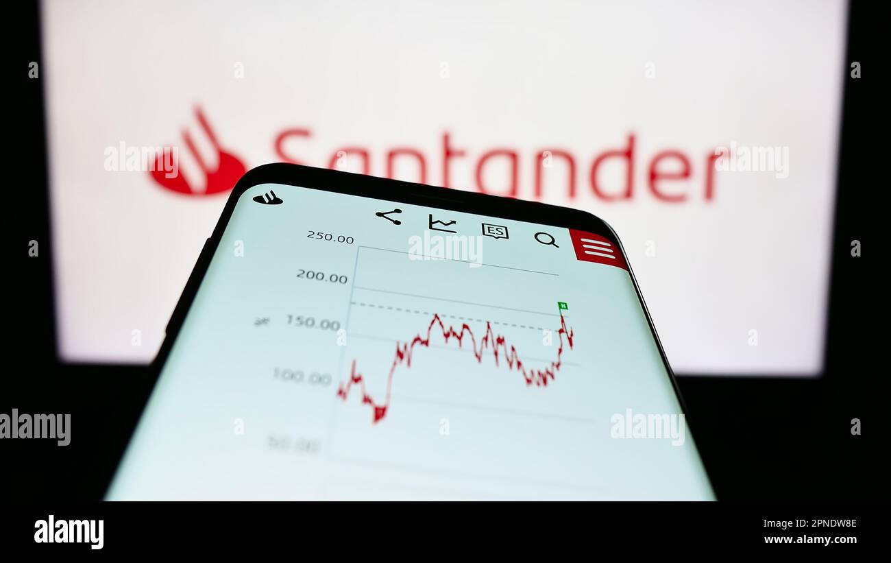 Smartphone with website of Spanish banking company Banco Santander S.A. on screen in front of business logo. Focus on top-left of phone display. Stock Photo
