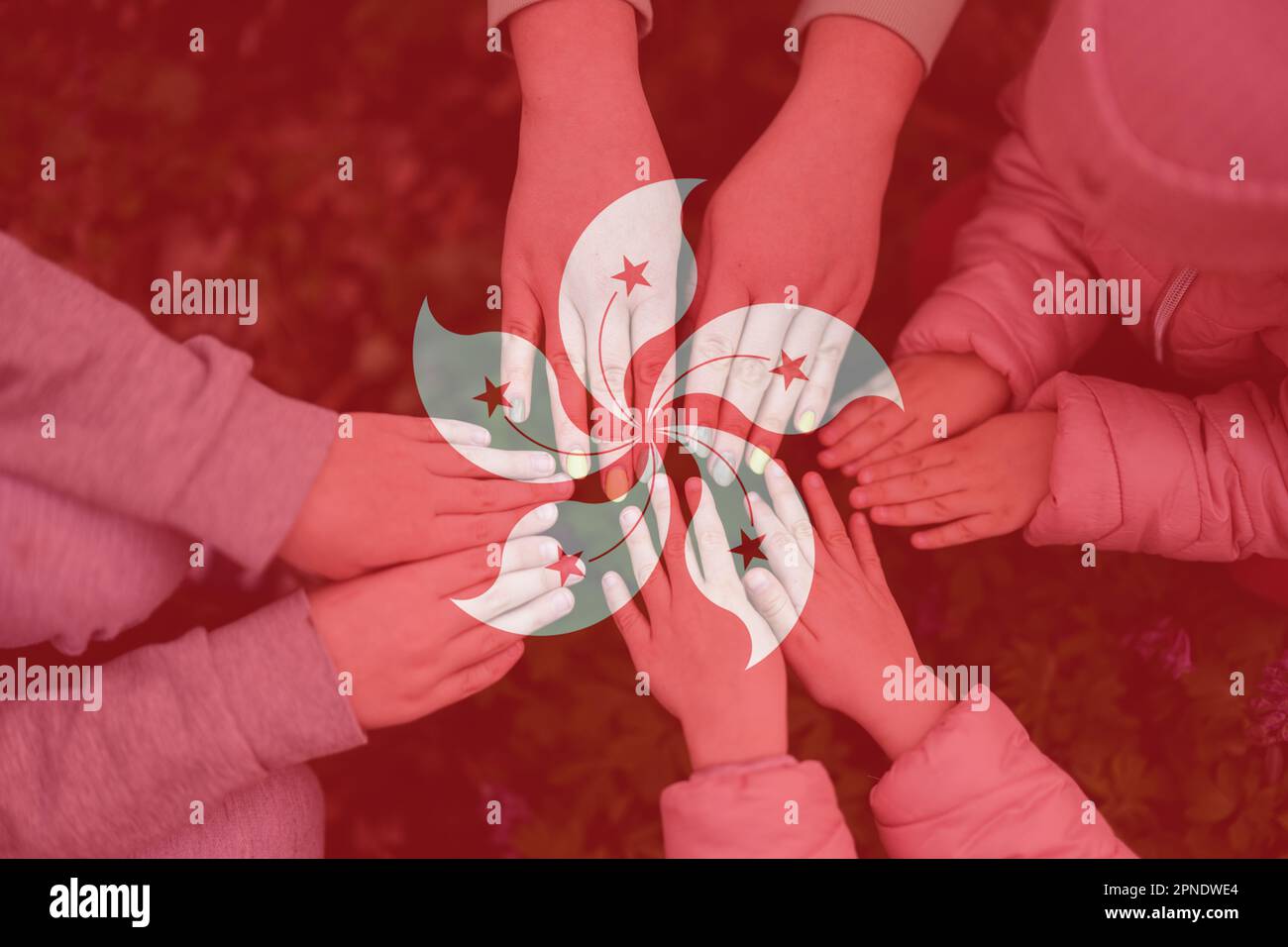 Hands of kids on background of Hong Kong  flag. Hongkonger patriotism and unity concept. Stock Photo