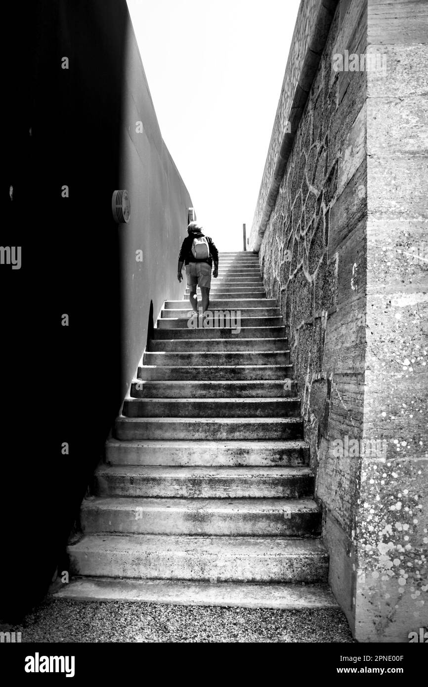 Alicante, Spain April 18, 2023 Young woman climbing stone stairs in