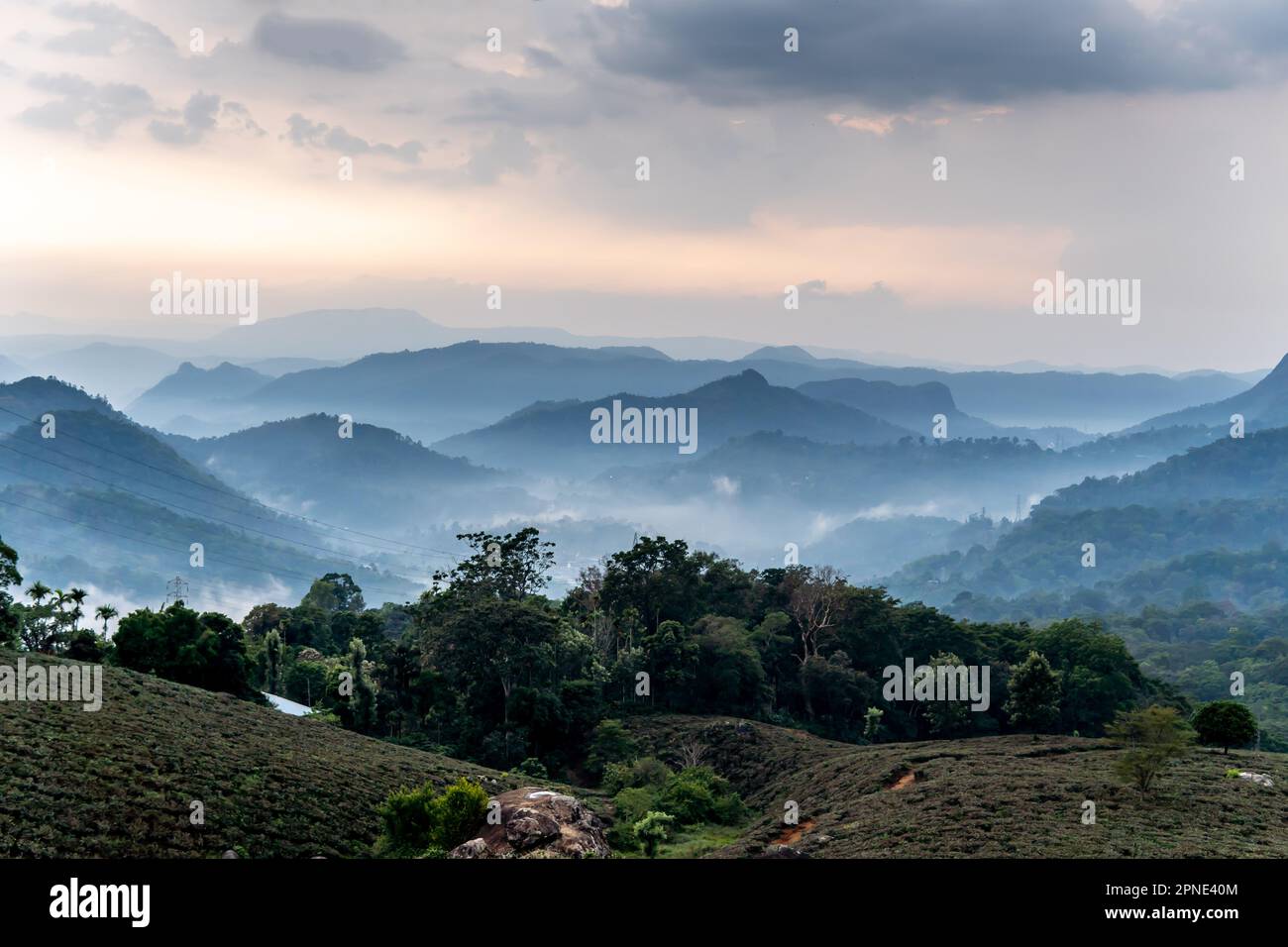 A magnificent scene of vast mountains covered in fluffy clouds and shimmering dew enchants the senses. Stock Photo