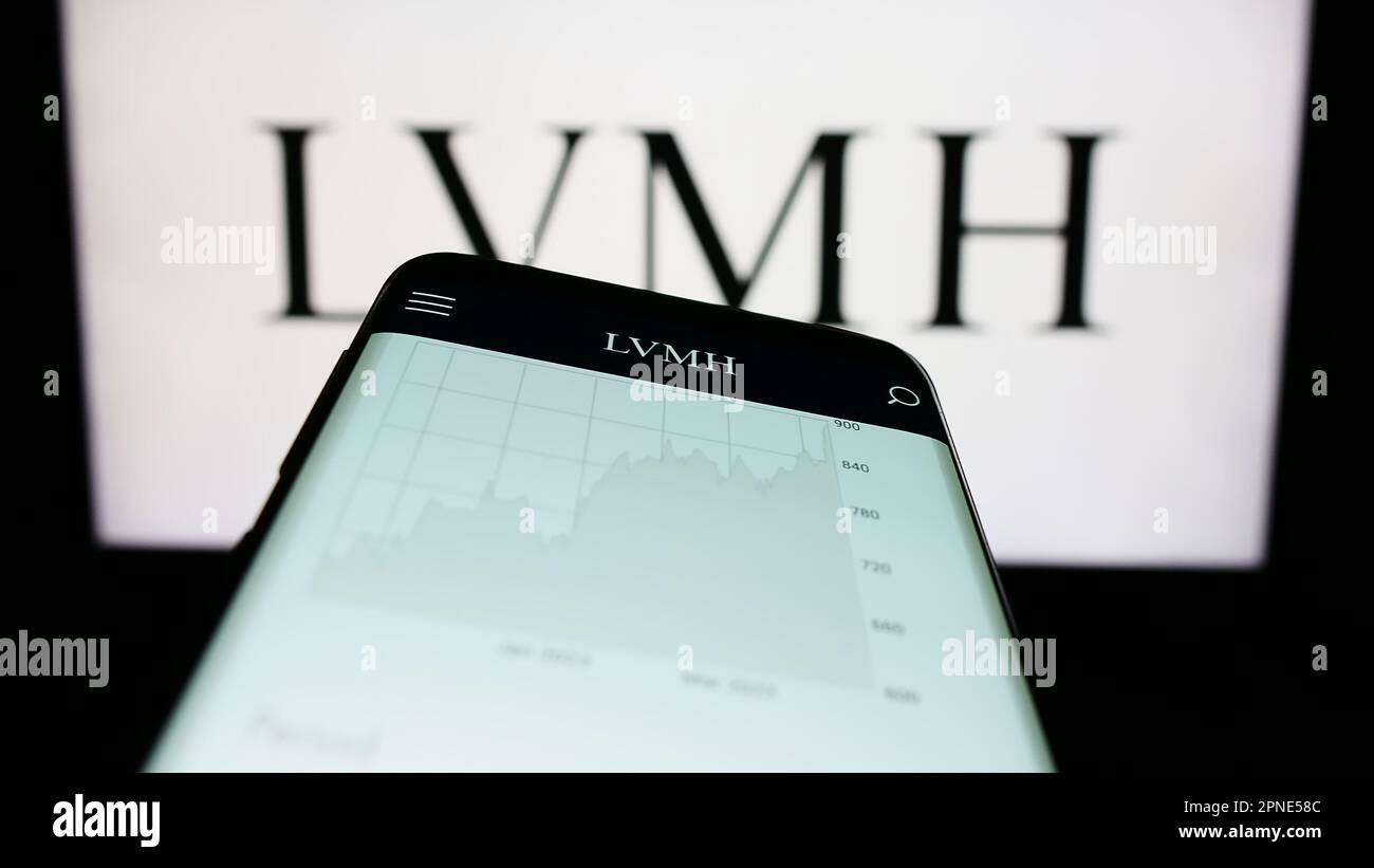 Smartphone with website of company LVMH Moet Hennessy Louis Vuitton SE on screen in front of business logo. Focus on top-left of phone display. Stock Photo