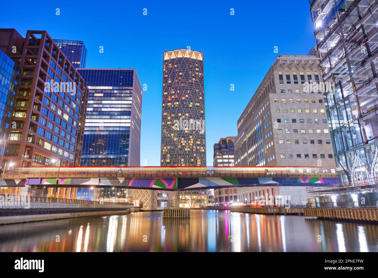 The elevated railway passing by the Canary Wharf Middle Dock, London, United Kingdom. Stock Photo