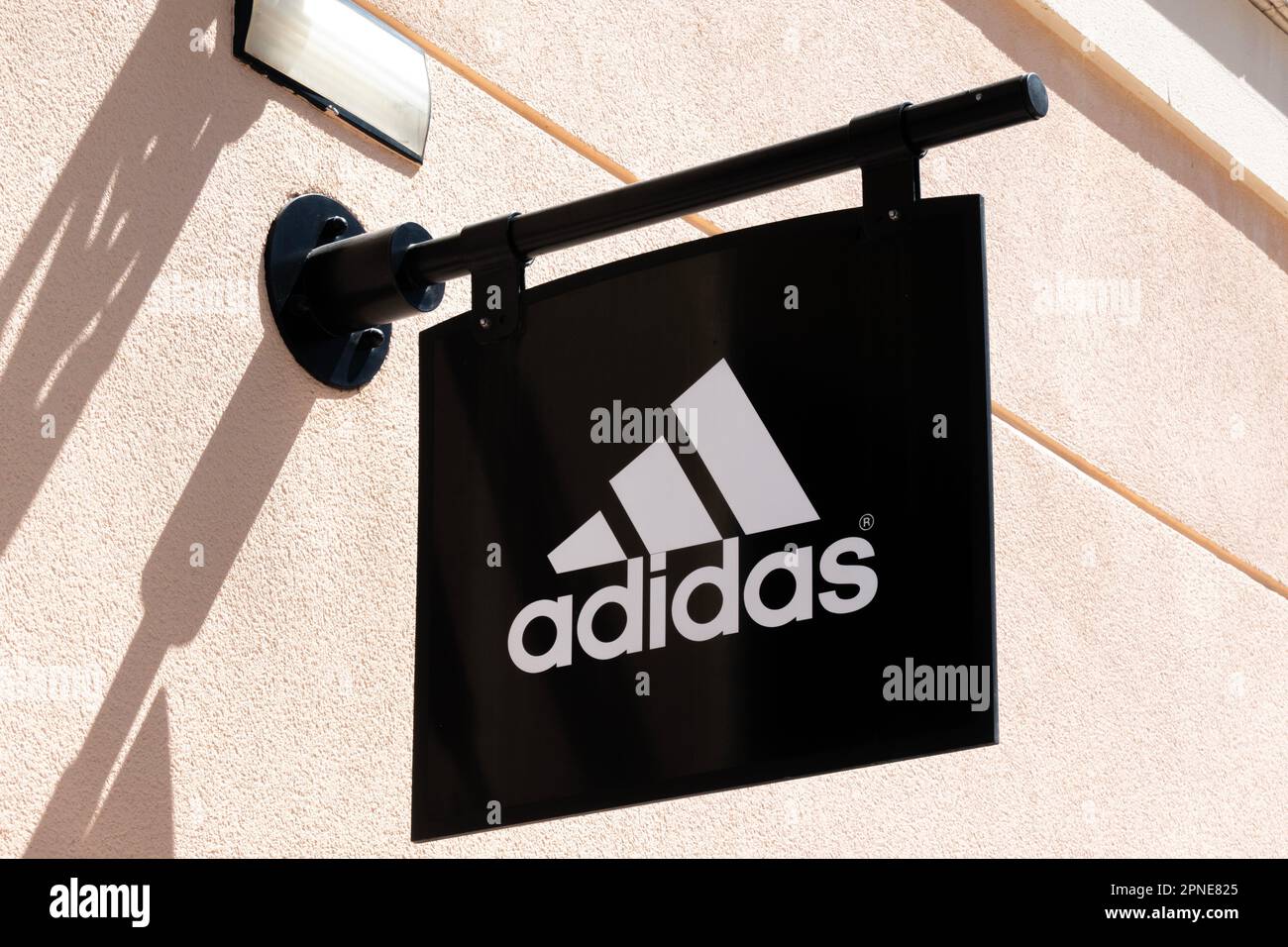 Orihuela Costa, Alicante, Spain - April 12, 2023: Adidas logo sign on wall  of Adidas store. Adidas is multinational sportswear brand that designs and  Stock Photo - Alamy