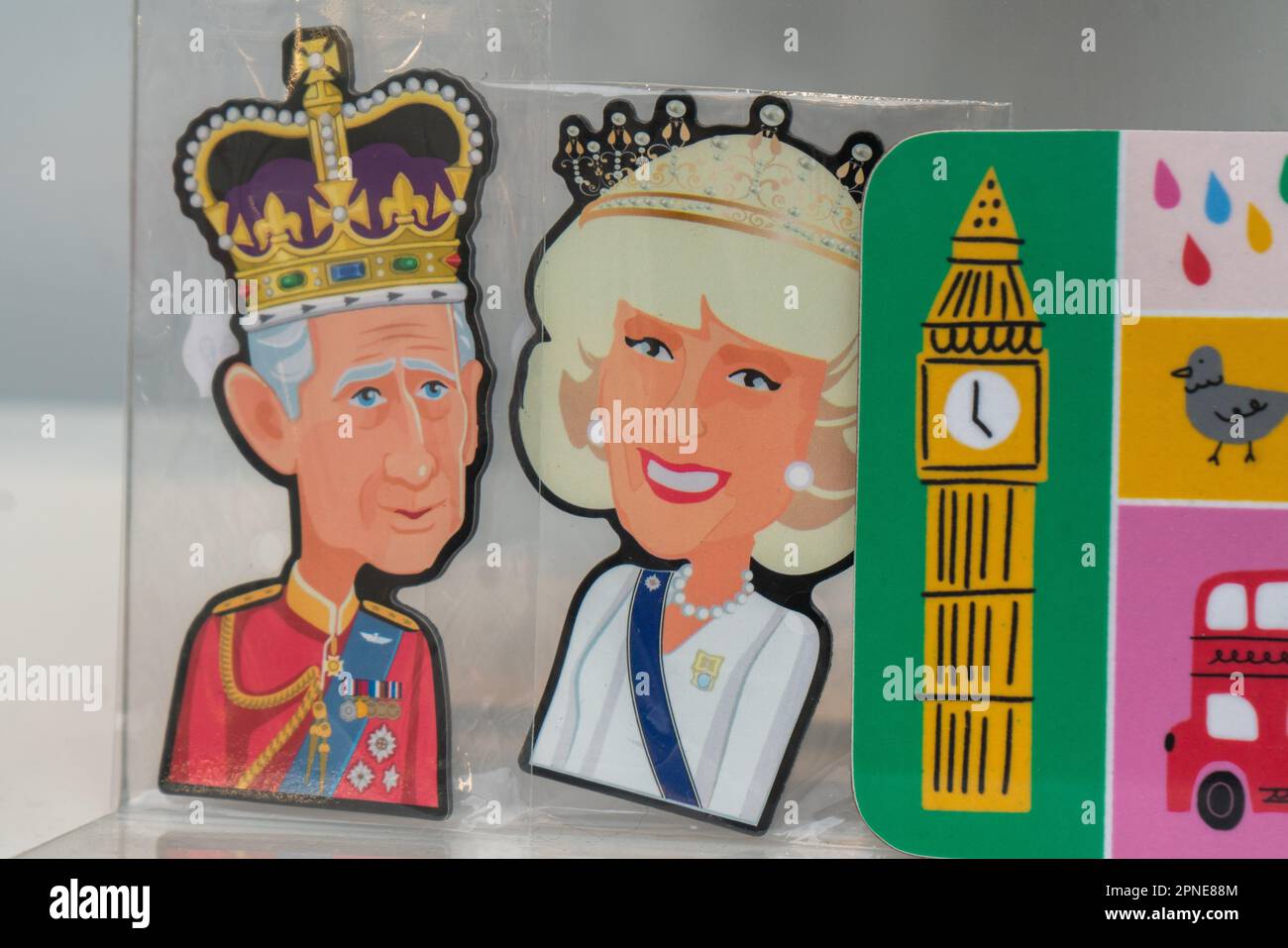 Coronation memorabilia featuring King Charles III and Camilla Queen consort displayed in a shop window in  central London Stock Photo