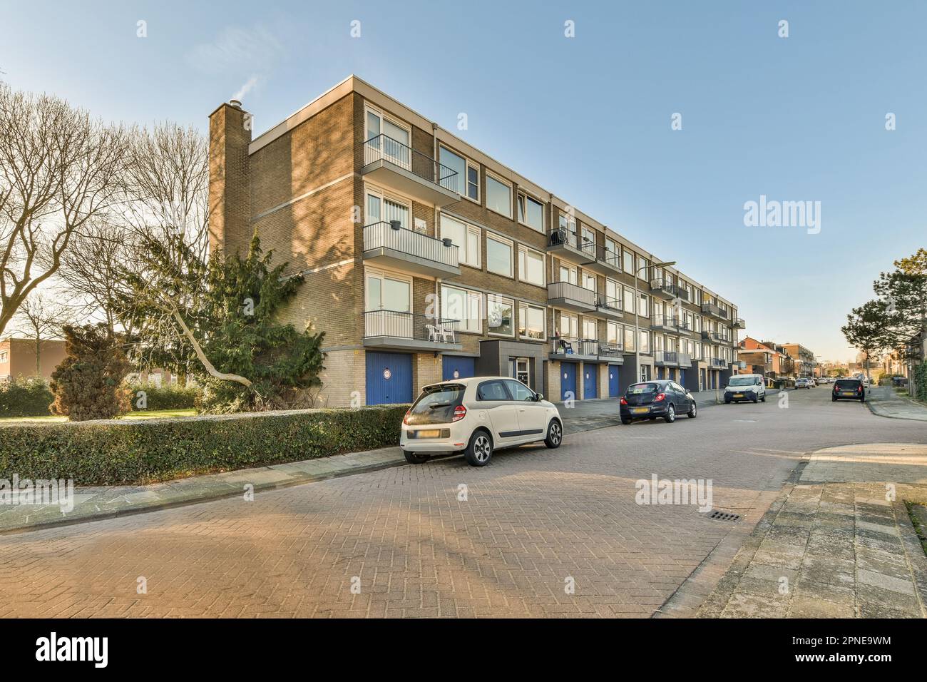 an apartment complex with cars parked in the driveway and trees on ...