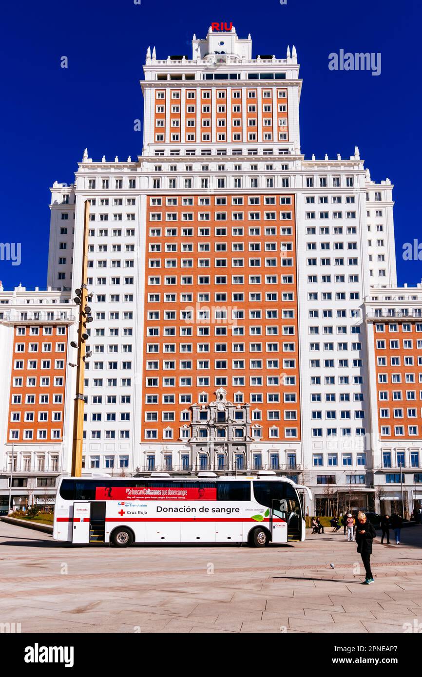 Hotel Riu Plaza España, Edificio España, Spain Building, and blood donation bus. It is an example of 20th-century Spanish architecture built in the ne Stock Photo