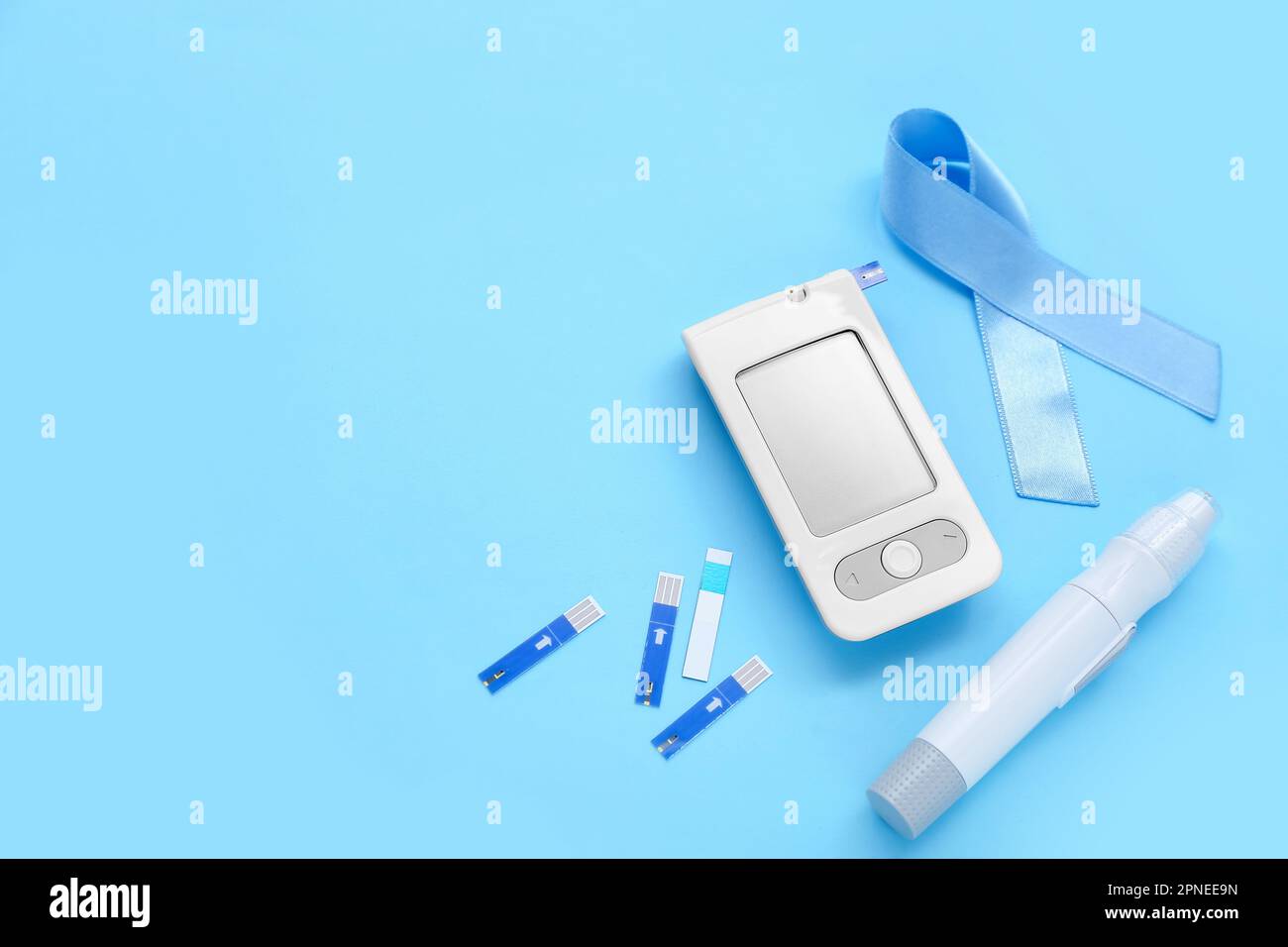 Awareness ribbon with glucometer and lancet pen on blue background ...