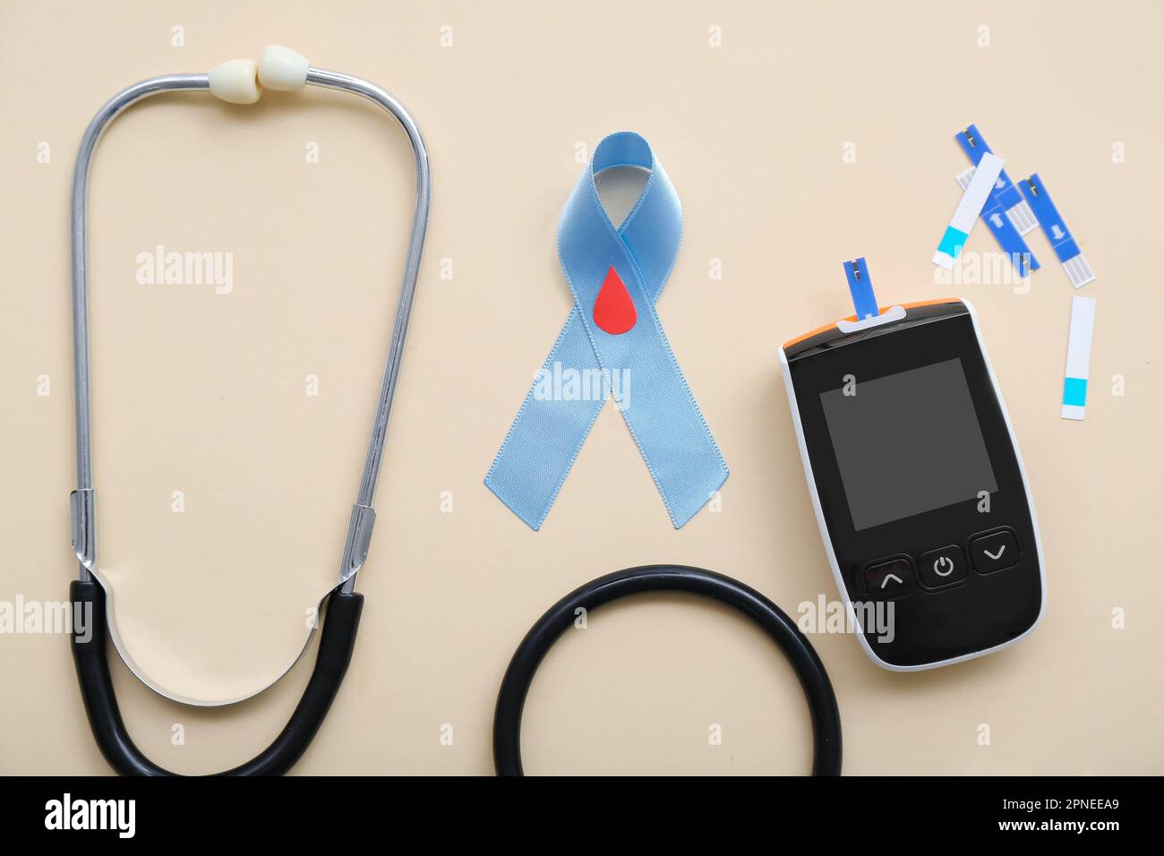 Awareness ribbon with glucometer, strips and stethoscope on beige ...